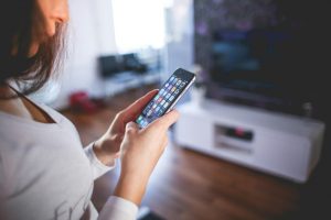 Frau am Mobiltelefon überprüft Smart Home und das Energiemanagement